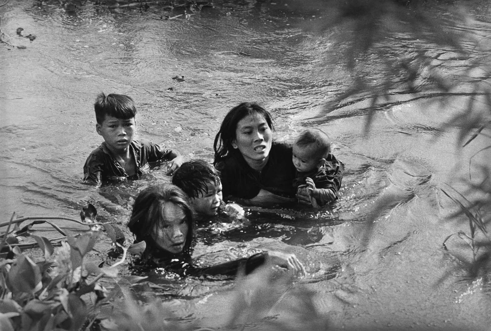 Une mère et ses enfants traverser à gué une rivière pour échapper bombardements AMÉRICAINS, 1965