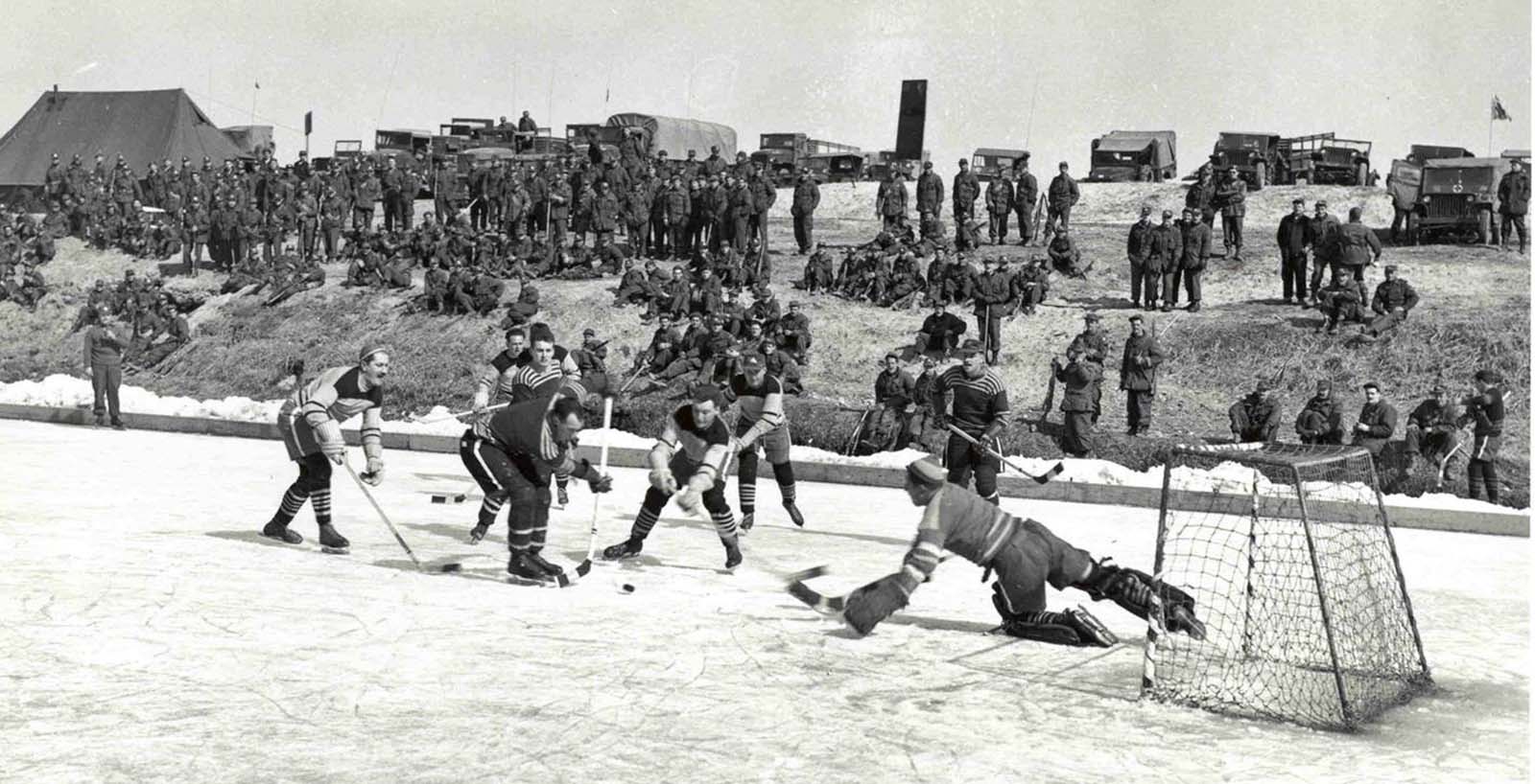 Soldats canadiens de jouer au hockey sur une patinoire ils ont construit en Corée, 1952