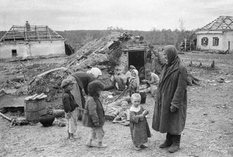 Femmes avec enfants dans un village soviétique en ruine