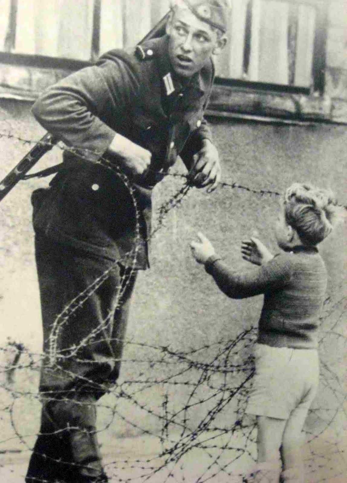 Est soldat allemand en aide à un petit garçon se faufiler à travers le Mur de Berlin, 1961