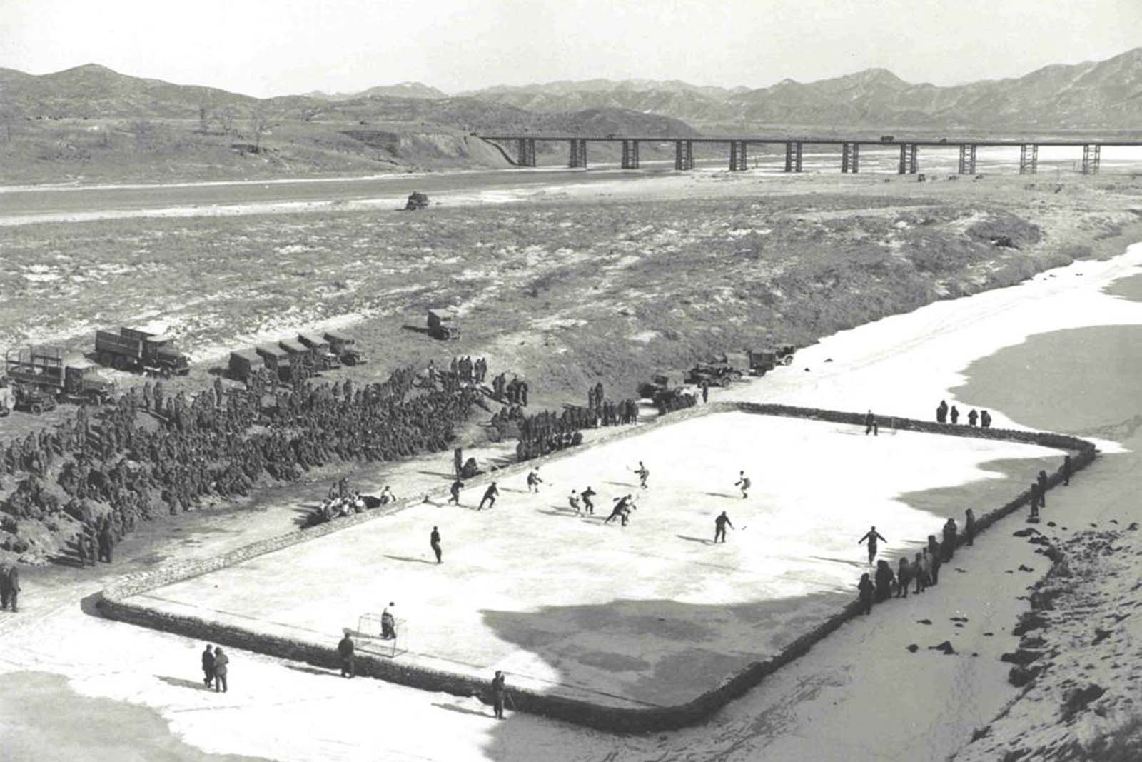 Soldats canadiens de jouer au hockey sur une patinoire ils ont construit en Corée, 1952