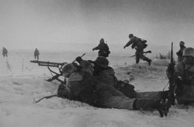 Le calcul d'une mitrailleuse MG 34 couvre la promotion des soldats allemands sur la neige-couvertes champ