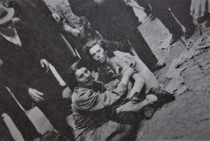 Deux juive, assis aux pieds des participants pogrom occupé par les troupes allemandes Lviv