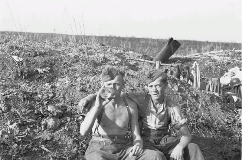 Deux soldats de la 167 ème division d'infanterie de la wehrmacht boivent dans les tranchées
