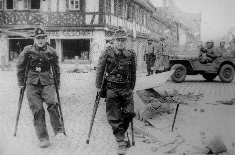 Deux prisonniers jeunes de l #39 allemand avec des béquilles et les soldats