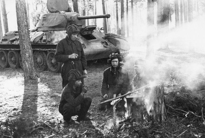 L'équipage du char soviétique T-34 après la bataille prépare le déjeuner dans la forêt