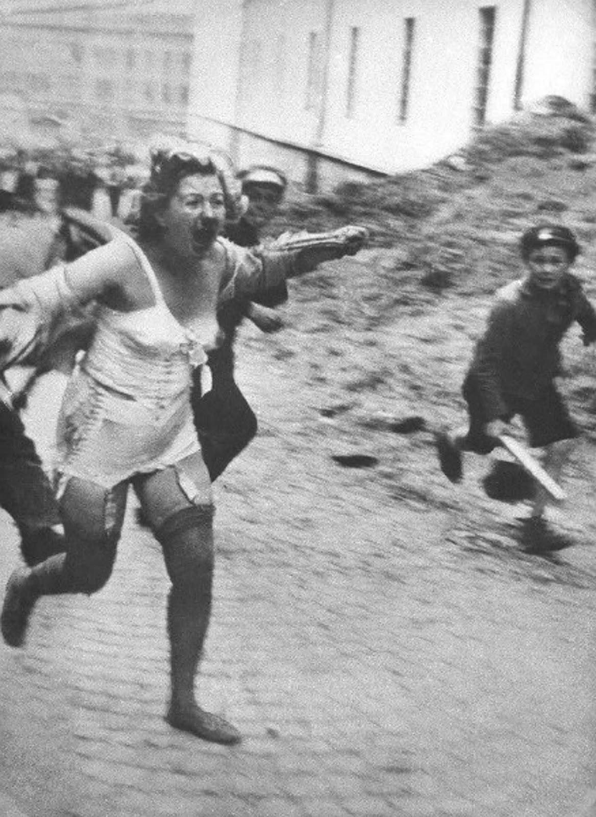 Femme juive poursuivie par des hommes et des jeunes armés de gourdins lors des pogroms de Lviv, 1941