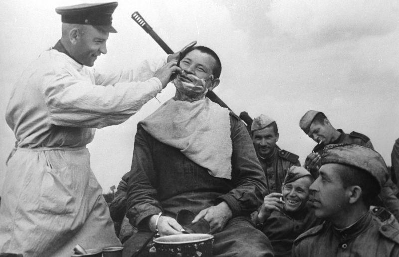 Le coiffeur du 1760e soldat de l'Armée rouge ZENAP K.M. Wilderman rase le soldat de l'Armée rouge V. Khamidulin. 1943 g.